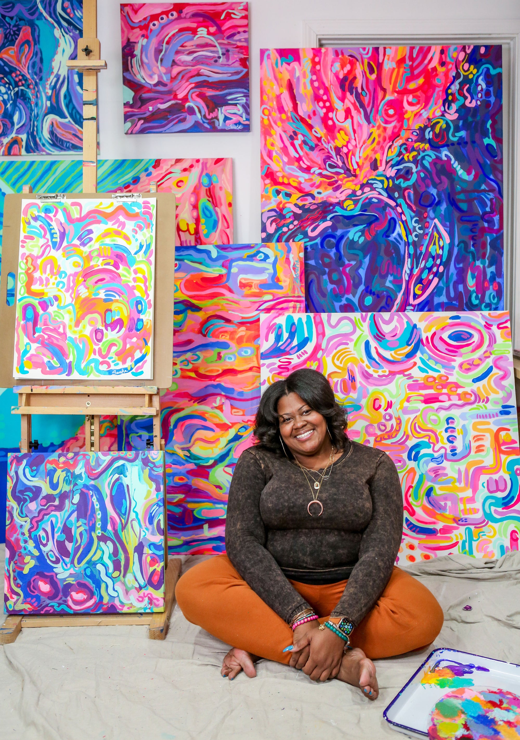 Detroit born Abstract Artist Sareka Unique Sitting in her Ypsilanti Studio in front of her abstract artwork