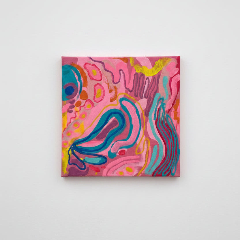 A square abstract canvas painting with swirling pink, teal, purple, yellow, and orange patterns, displayed on a white gallery pedestal with a blurred art museum background.